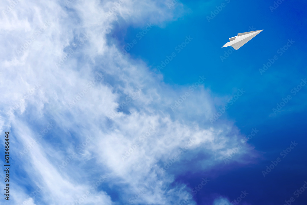 Fototapeta premium White clouds and paper airplane flying in blue sky on sunny day. Space for text
