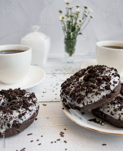 Chocolate donuts with cup of coffee. on white wooden table.
