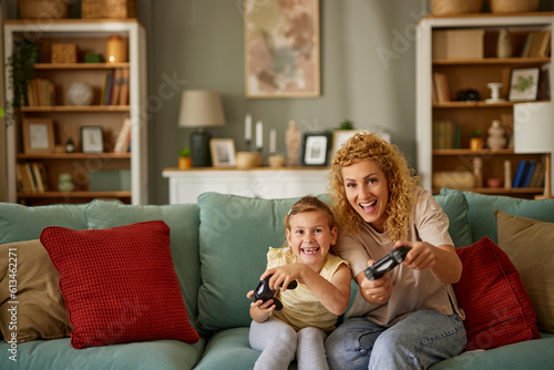 Mother and daughter playing video games at home