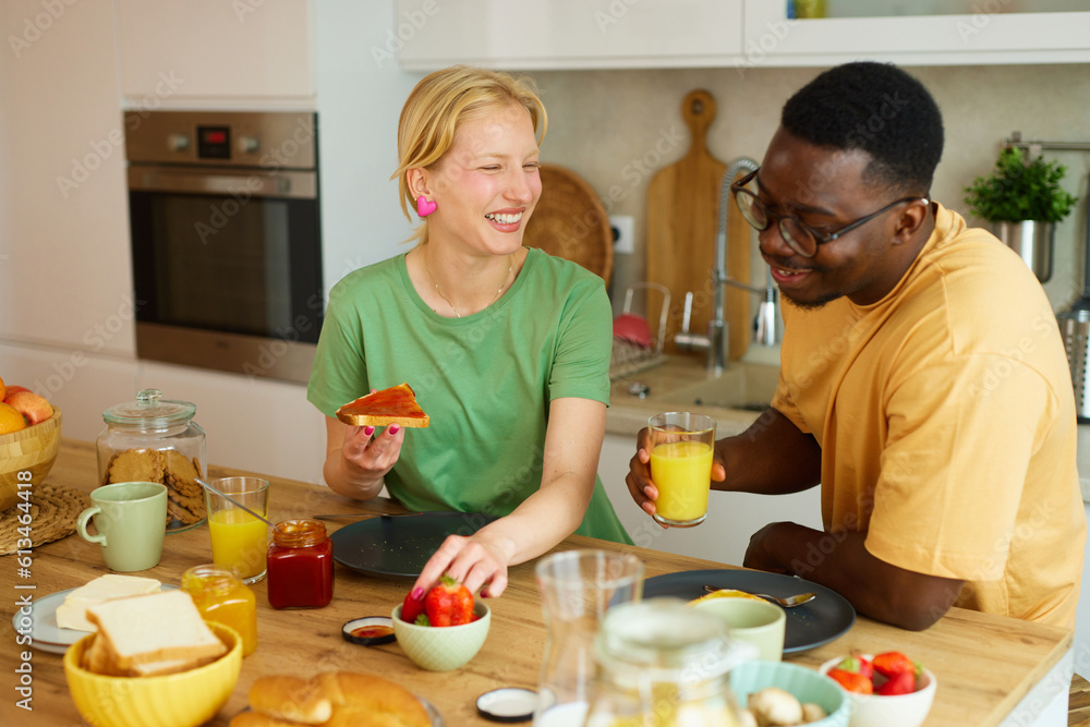 Multiracial couple enjoying breakfast together at home Multiracial couple enjoying breakfast together at home