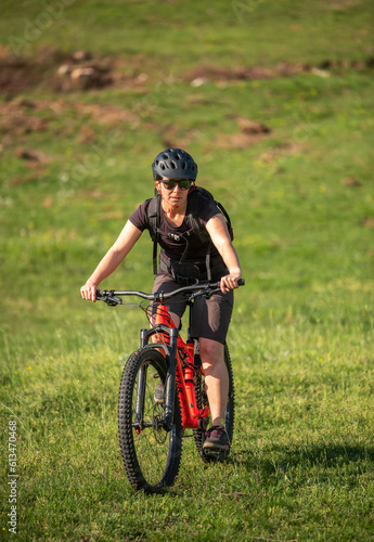 Female cycling on her mountain bike through the countryside on a sunny day.