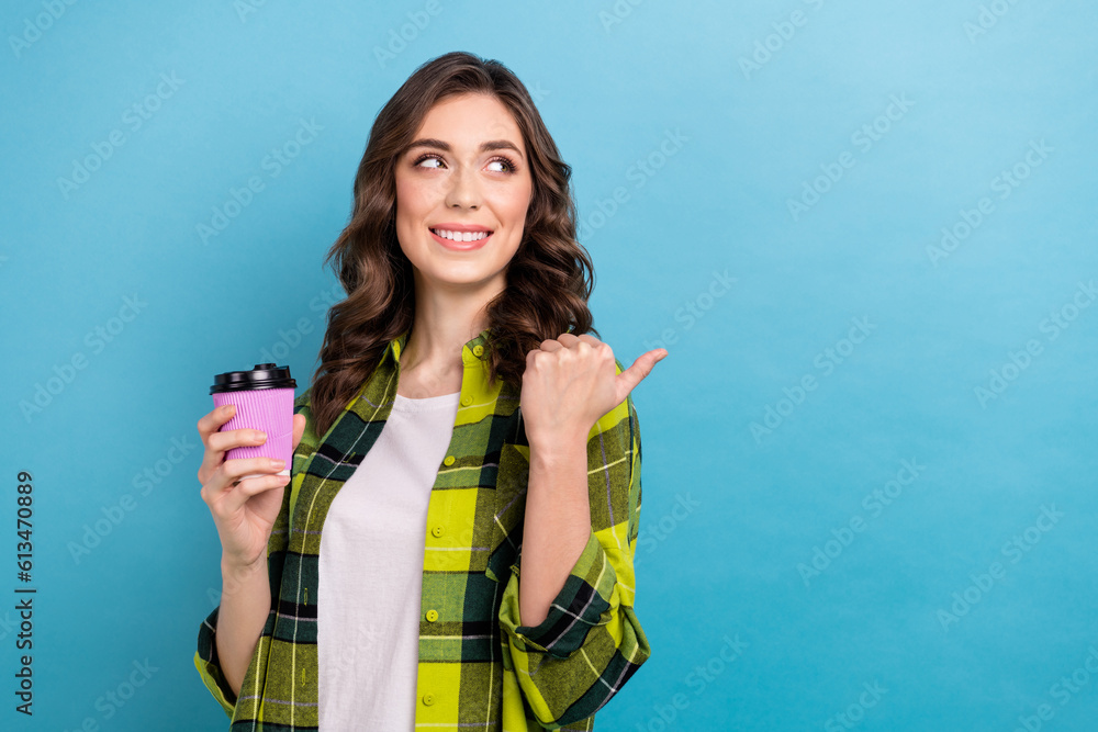 Photo of pretty person hand hold coffee cup look indicate finger empty space isolated on blue color background Photo of pretty person hand hold coffee cup look indicate finger empty space isolated on blue color background