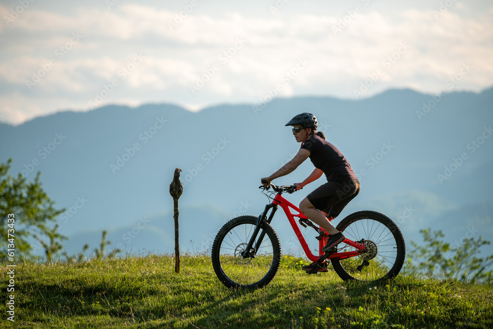 Female cycling on her mountain bike through the countryside on a sunny day.