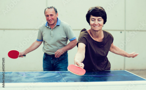  Happy mature spouses playing table tennis