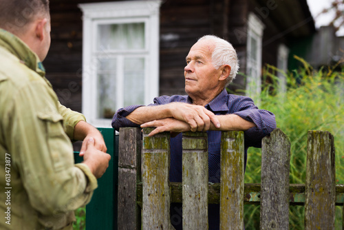 Good neighbors talk on border of their farms photo