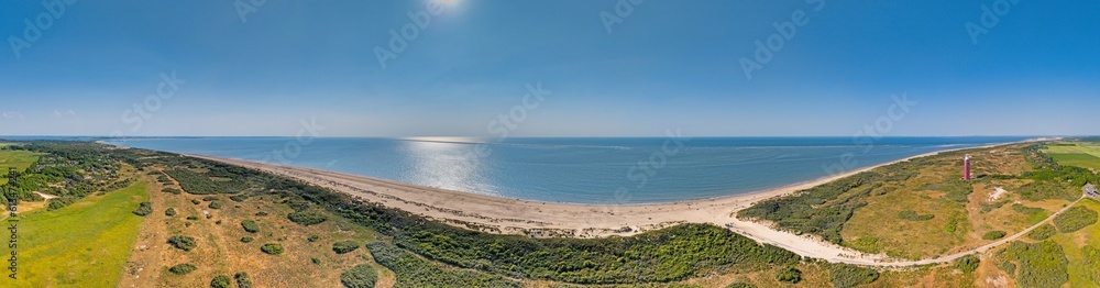 Drone panorama of Ouddorp lighthouse in Holland with surrounding dunes during daytime