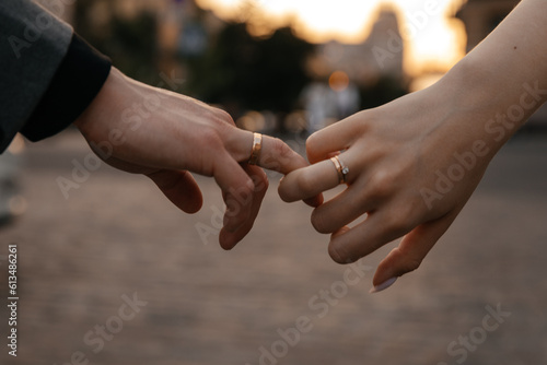 Entwining hands of lovers with wedding rings