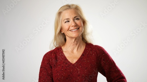 Attractive smiling happy beautiful mature middle age woman looking away off camera isolated on solid white background. Concept of beauty is ageless.