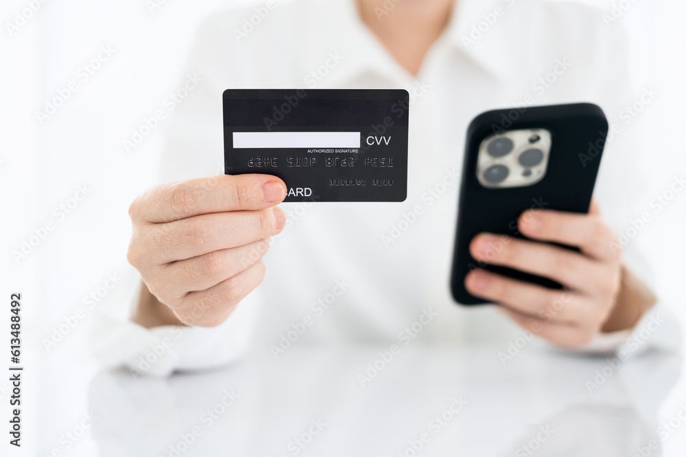 Close up view, young asian woman holding credit card and smart phone to shopping online and paying her order, People relax on holiday use technology from smart phone for the convenience of daily use Close up view, young asian woman holding credit card and smart phone to shopping online and paying her order, People relax on holiday use technology from smart phone for the convenience of daily use