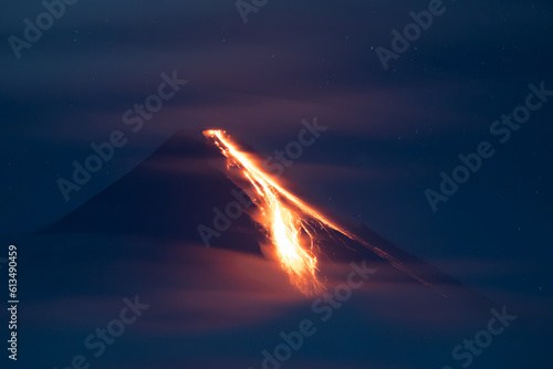 volcano erupting at night spewing lava