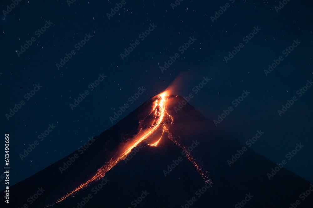 volcano erupting at night spewing lava