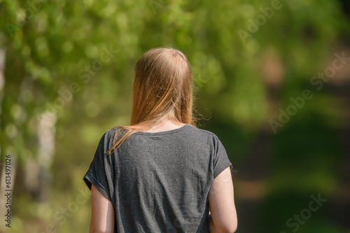 Zgarbiona kobieta idąca przez park photo
