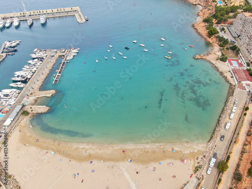Mallorca resort . Aerial view of the beach shore, turquoise waters, white sand, umbrellas, sun beds. Summer holiday destination with hotels, restaurants and amenities for tourist 