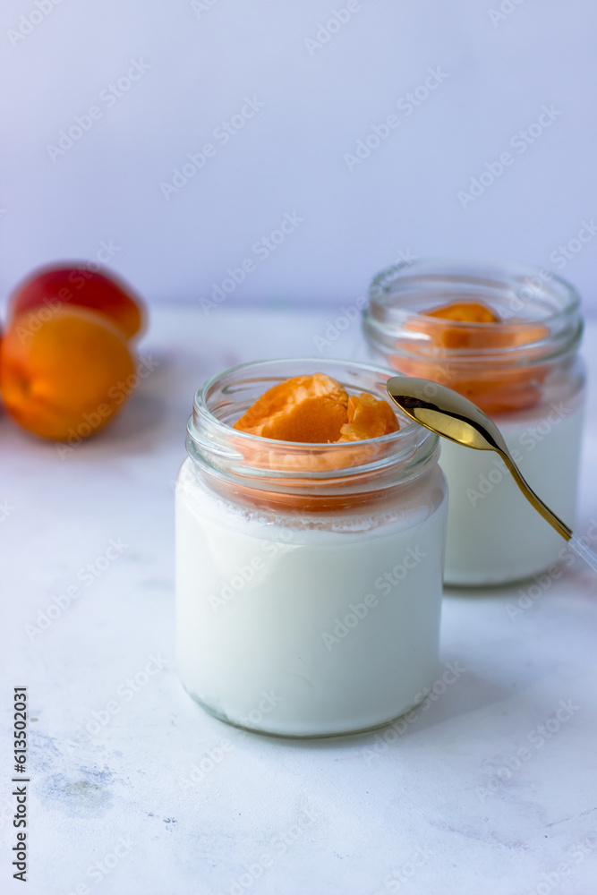 Homemade yogurt with juicy apricots. Yogurt on a white table Homemade yogurt with juicy apricots. Yogurt on a white table