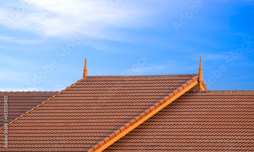 2 levels of Brown ceramic tile roof in vintage style against blue sky background 