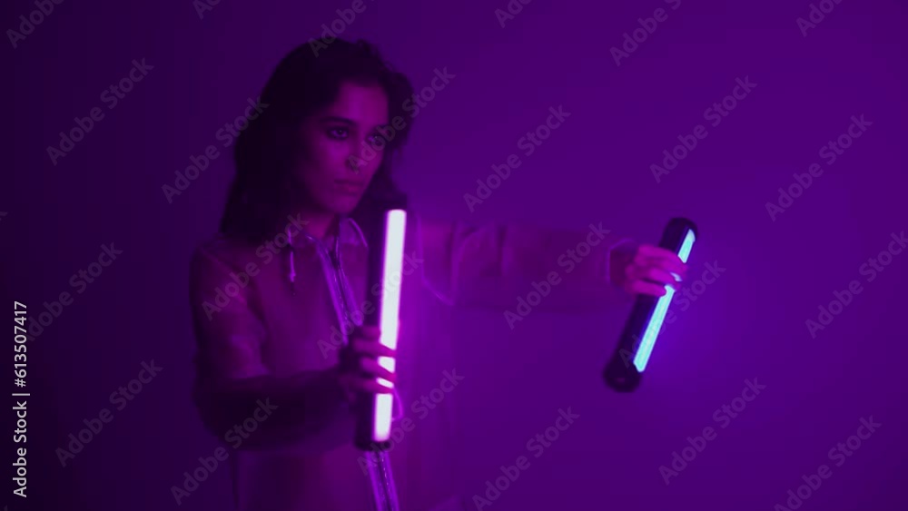 Woman in futuristic costume. Girl in glasses of virtual reality while touching air. Augmented reality game, future technology, AI concept. VR. Neon blue and red light. Dark background. Woman in futuristic costume. Girl in glasses of virtual reality while touching air. Augmented reality game, future technology, AI concept. VR. Neon blue and red light. Dark background.