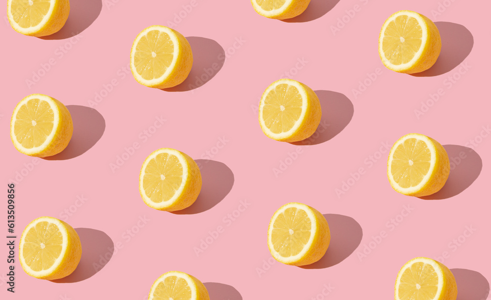 Trendy sunlight summer fruit pattern made with yellow lemon slice on bright light pink background. Minimal summer concept. Creative food idea. lemons aesthetic.