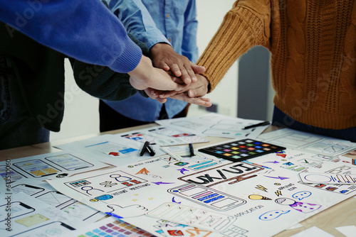ux developers and ui designers use augmented reality to brainstorm on mobile app and web site page interface wireframe designs on modern office desks. successful, deal, success, together concepts.