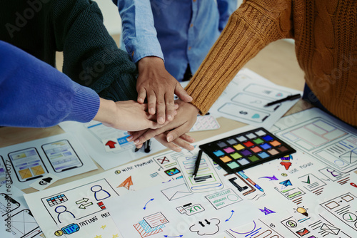 ux developers and ui designers use augmented reality to brainstorm on mobile app and web site page interface wireframe designs on modern office desks. successful, deal, success, together concepts.