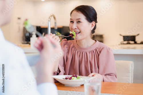 Plakat w ramie 夫婦で楽しくご飯を食べる高齢女性