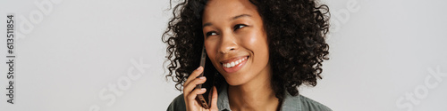 Black young woman smiling and talking on cellphone