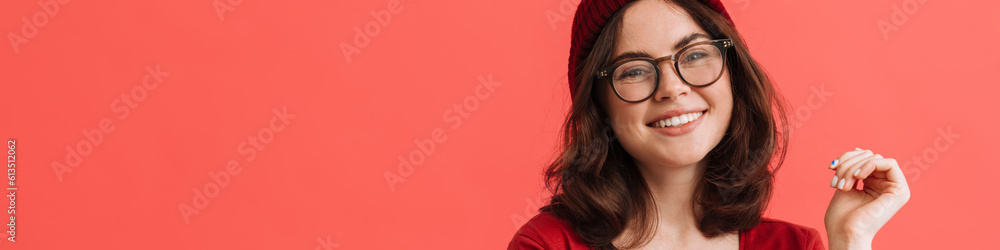 Young happy girl wearing hat and eyeglasses posing at camera Young happy girl wearing hat and eyeglasses posing at camera