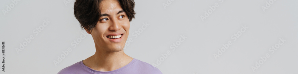 Young asian smiling boy in violet t-shirt holding phone Young asian smiling boy in violet t-shirt holding phone