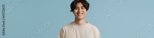 Young handsome smiling asian boy with hands in pockets