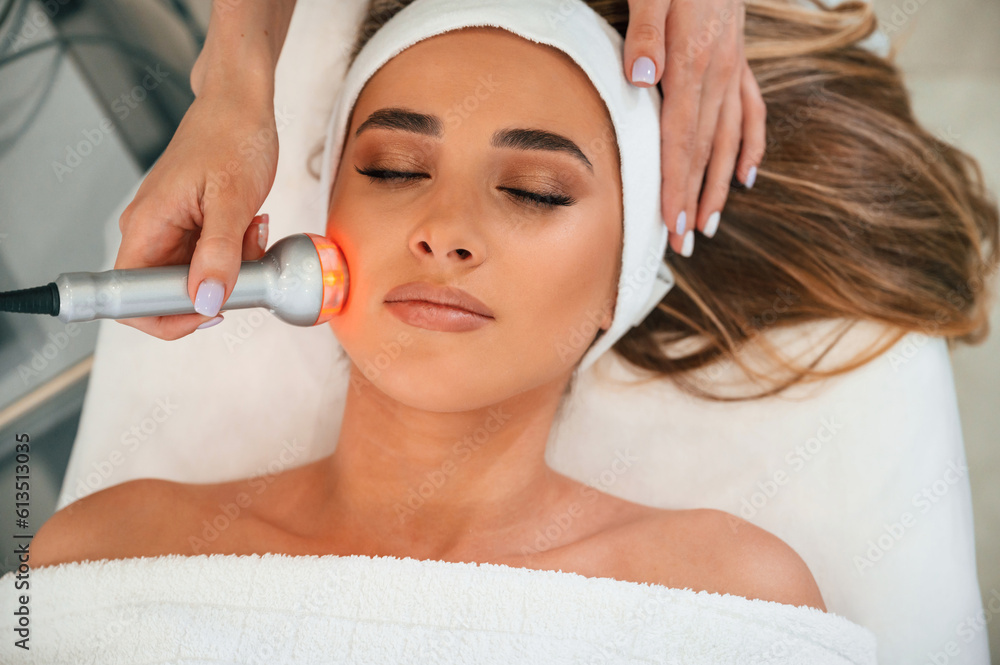 Apparatus for galvanization is used. Woman face getting facial care by beautician hands at spa salon