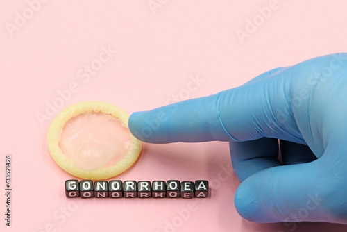 Canvas Print Doctor's hand pointing to a condom