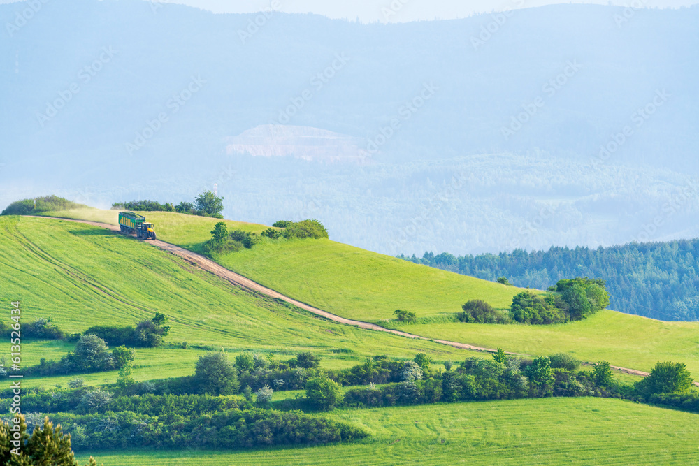 An agricultural vehicle with a load descends the picturesque Rolling Hills in Slovakia.