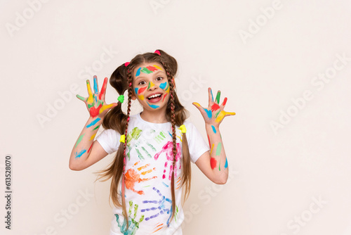Painted hands and face. Portrait of a girl child stained in multicolored paint. Children's artistic creativity. Isolated white background.