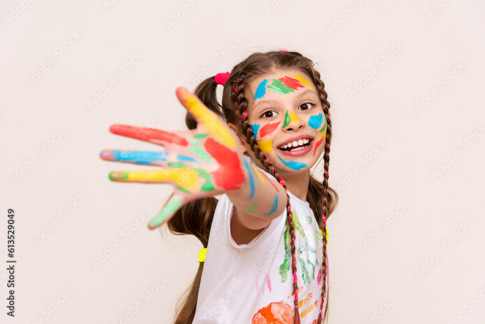 Painted hands and face. Portrait of a girl child stained in multicolored paint. Children's artistic creativity. Isolated white background. Painted hands and face. Portrait of a girl child stained in multicolored paint. Children's artistic creativity. Isolated white background.