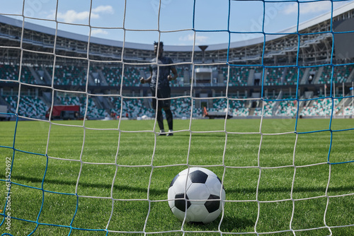 soccer player kicks the ball into the goal at the stadium