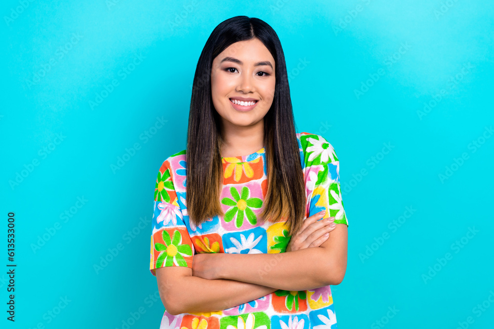 Photo of charming positive woman dressed flower print t-shirt smiling arms crossed isolated teal color background Photo of charming positive woman dressed flower print t-shirt smiling arms crossed isolated teal color background