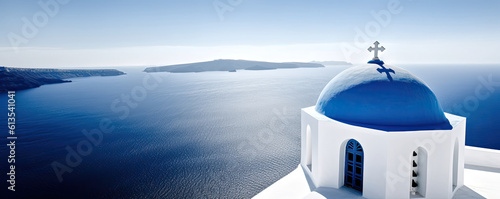 Greek style church with blue dome and cross overlooking the ocean. photo