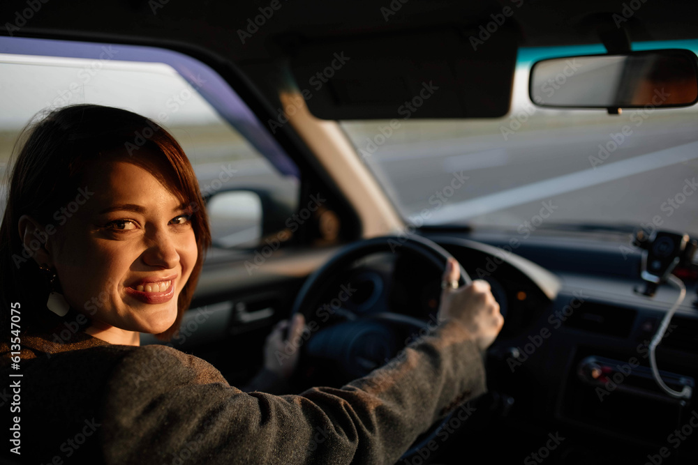 beautiful woman driver driving a car at sunset on a journey. beautiful woman driver driving a car at sunset on a journey.