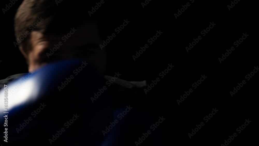 Close-up of male boxer shadowboxing in the dark, slow motion, opponent's pov Close-up of male boxer shadowboxing in the dark, slow motion, opponent's pov
