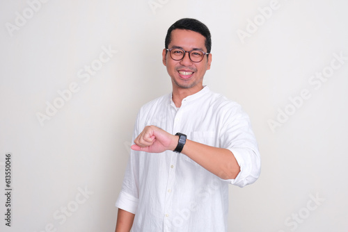 Adult Asian man smiling happy while showing his arm watch