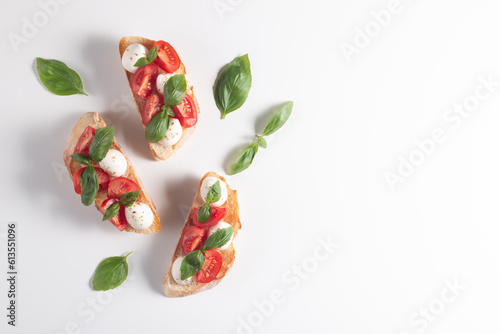 Tomato  basil and cheese fresh made caprese bruschetta. Italian tapas  antipasti with vegetables  herbs and oil on grilled ciabatta and baguette bread. Sandwich.