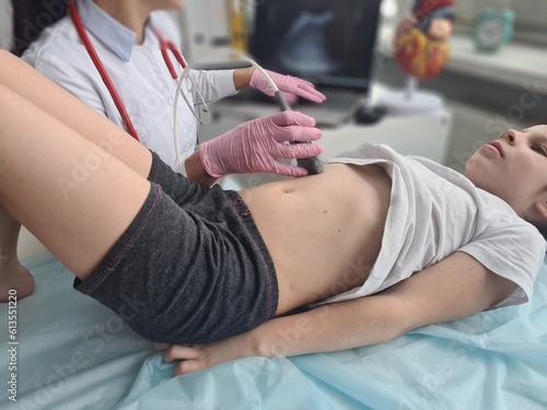 Doctor makes ultrasound of abdominal cavity for girl using scanner © Nadzeya