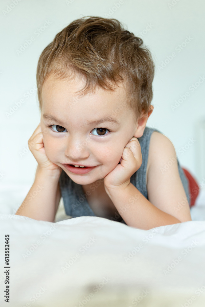 A little boy is playing in his room. Toddler. Khlorchik is happy and fooling around on his bed. Happy childhood. A little boy is playing in his room. Toddler. Khlorchik is happy and fooling around on his bed. Happy childhood.
