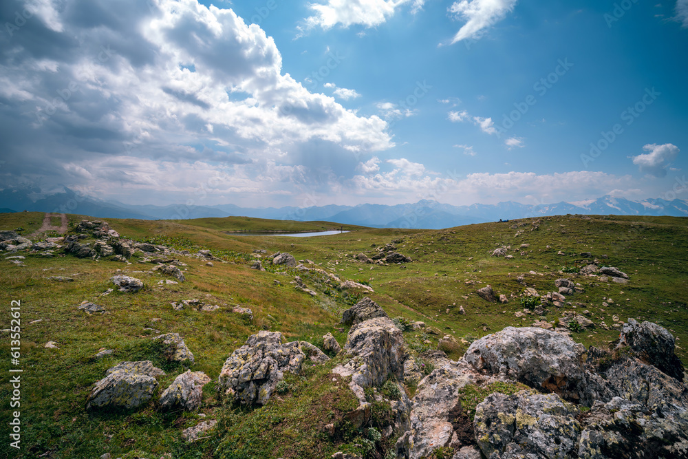 Caucasus mountains, Mestia, Svaneti region, Georgia. Summer day, green hills, high mountain pasture for livestock, white Nature and travel. Stones, boulders, rock.