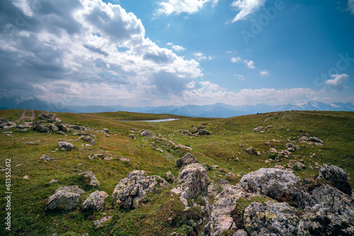 Caucasus mountains, Mestia, Svaneti region, Georgia. Summer day, green hills, high mountain pasture for livestock, white Nature and travel. Stones, boulders, rock. © Sergey