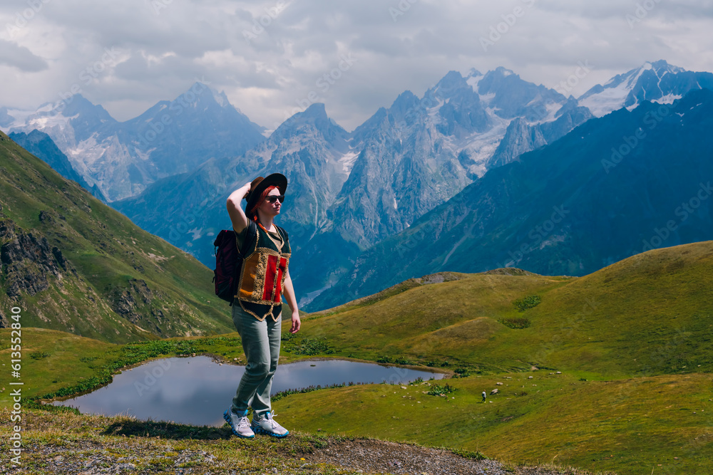 A woman at the Koruldi Lake with an amazing view on mountain ridges near Mestia in the Caucasus Mountain Range, Upper Svaneti, Country of Georgia. Wanderlust. Trekking. Copy space