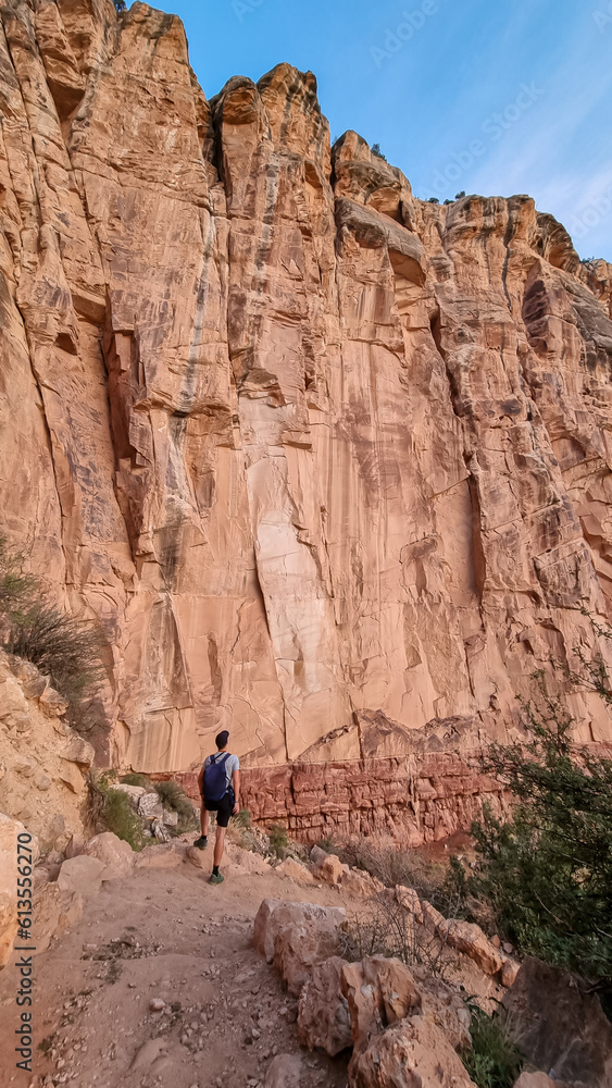 Man hiking along Bright Angel trail with panoramic aerial overlook of South Rim of Grand Canyon National Park, Arizona, USA, America. View on massiv cliffs, rock formations and steep stone walls