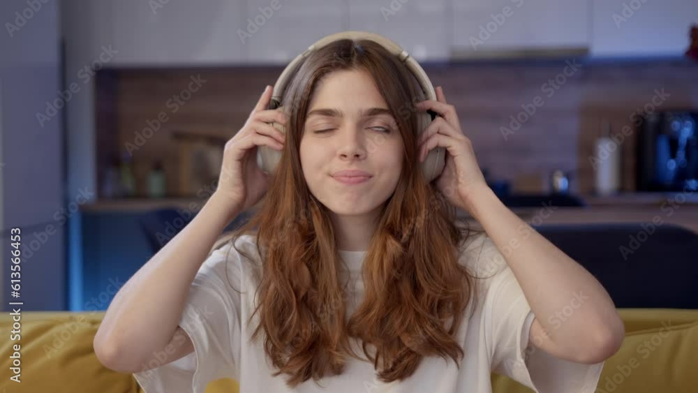 beautiful young curly woman puts on headphones with pleasure, smiles and dances. girl turns on music in overhead headphones and enjoys what she hears. Generation Z girl enjoy life beautiful young curly woman puts on headphones with pleasure, smiles and dances. girl turns on music in overhead headphones and enjoys what she hears. Generation Z girl enjoy life