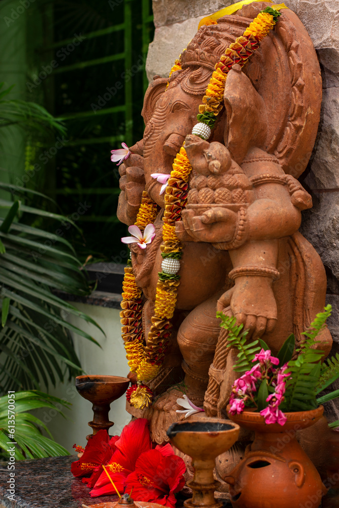 Beautiful green lord Ganesha statue with natural texture background.