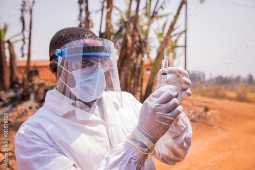 A doctor in Africa checks the vaccine syringe
