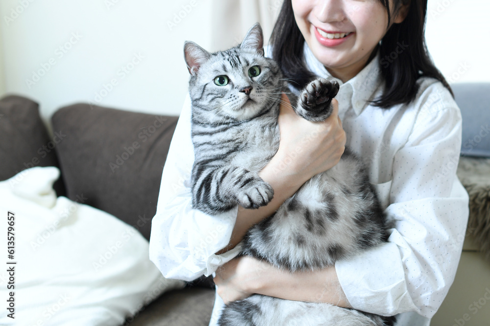 屋内で猫を抱っこする若い女性
屋内で猫を抱っこする若い女性